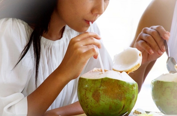 Người phụ nữ uống nước dừa tươi mát